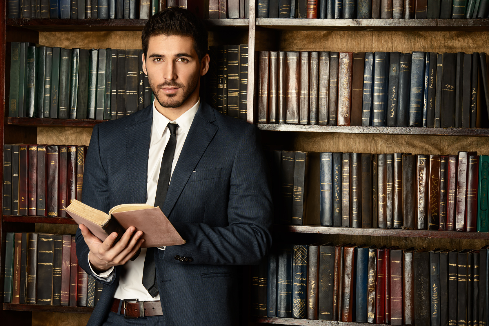 Respectable young man in the old library. Classic vintage interior.