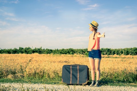 girl hitchhiking on his journey - people, holiday and lifestyle concept