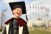 funny kid graduate against the background of the International University